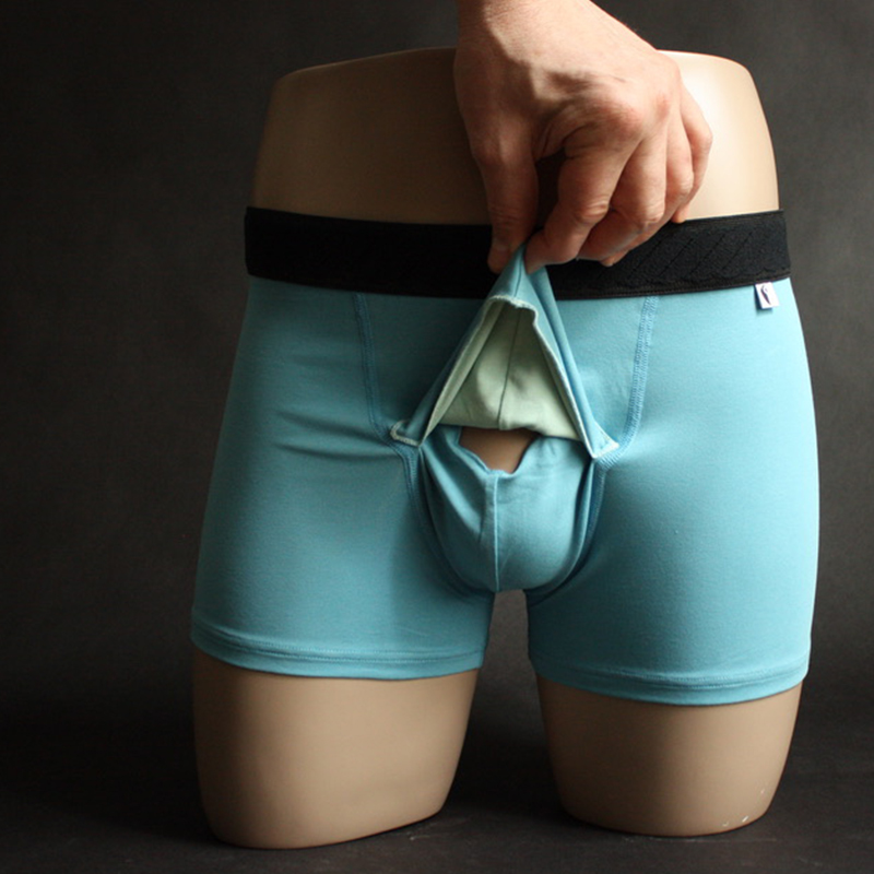 Boxer anatomique SABORDS® avec le volet de recouvrement relevé, laissant apparaître l’ouverture frontale anatomique. Toute la partie avant du boxer est ainsi dédiée au maintien des testicules, pour assurer un maintien naturel et confortable, tandis que la verge bénéficie d’un positionnement indépendant. Cette conception illustre le principe breveté SABORDS® : séparer le maintien testiculaire du positionnement de la verge.